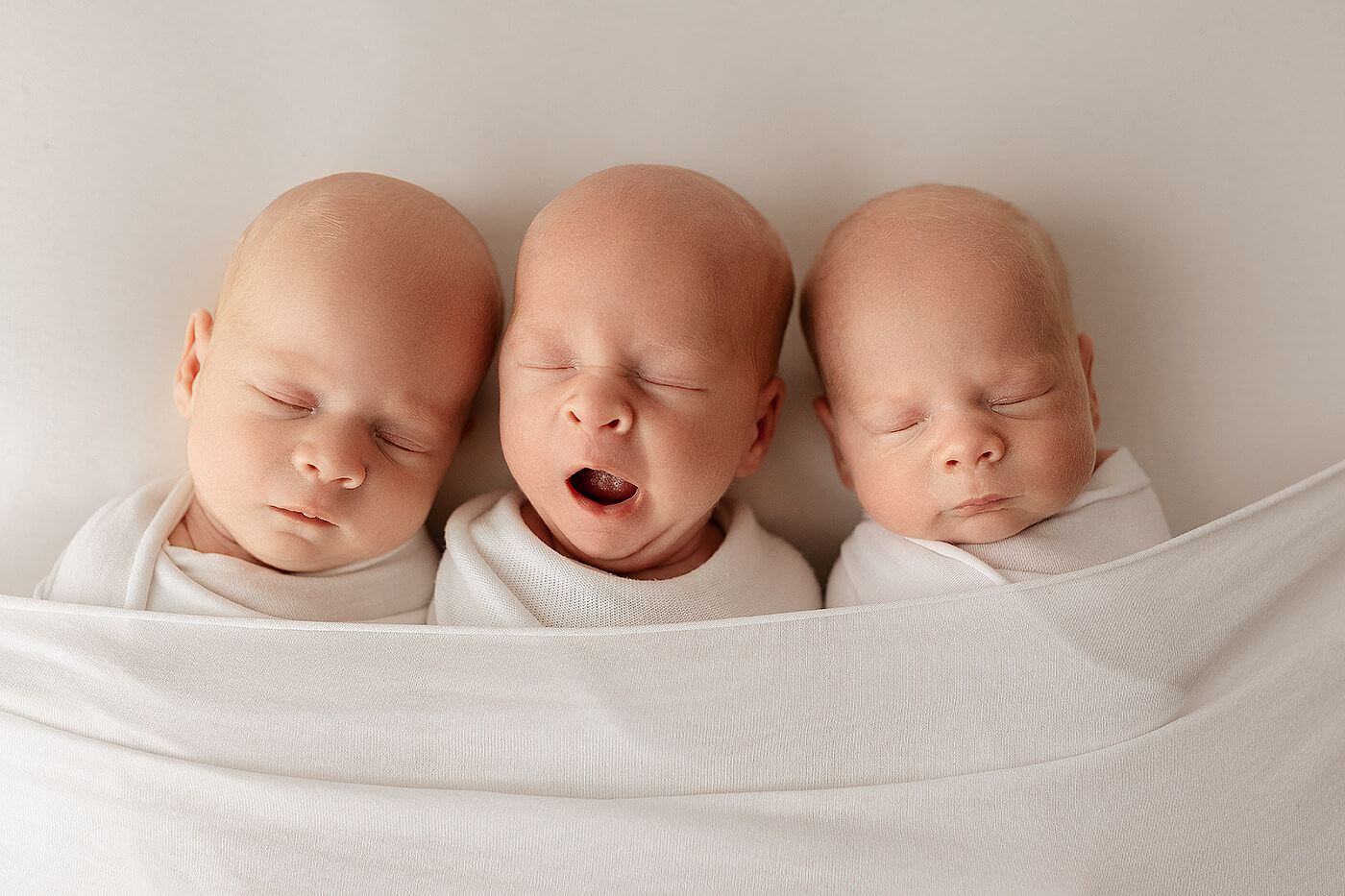 Sesja noworodkowa trojaczków. Sesja noworodkowa trojaczków w studio. Trzy śpiące noworodki.